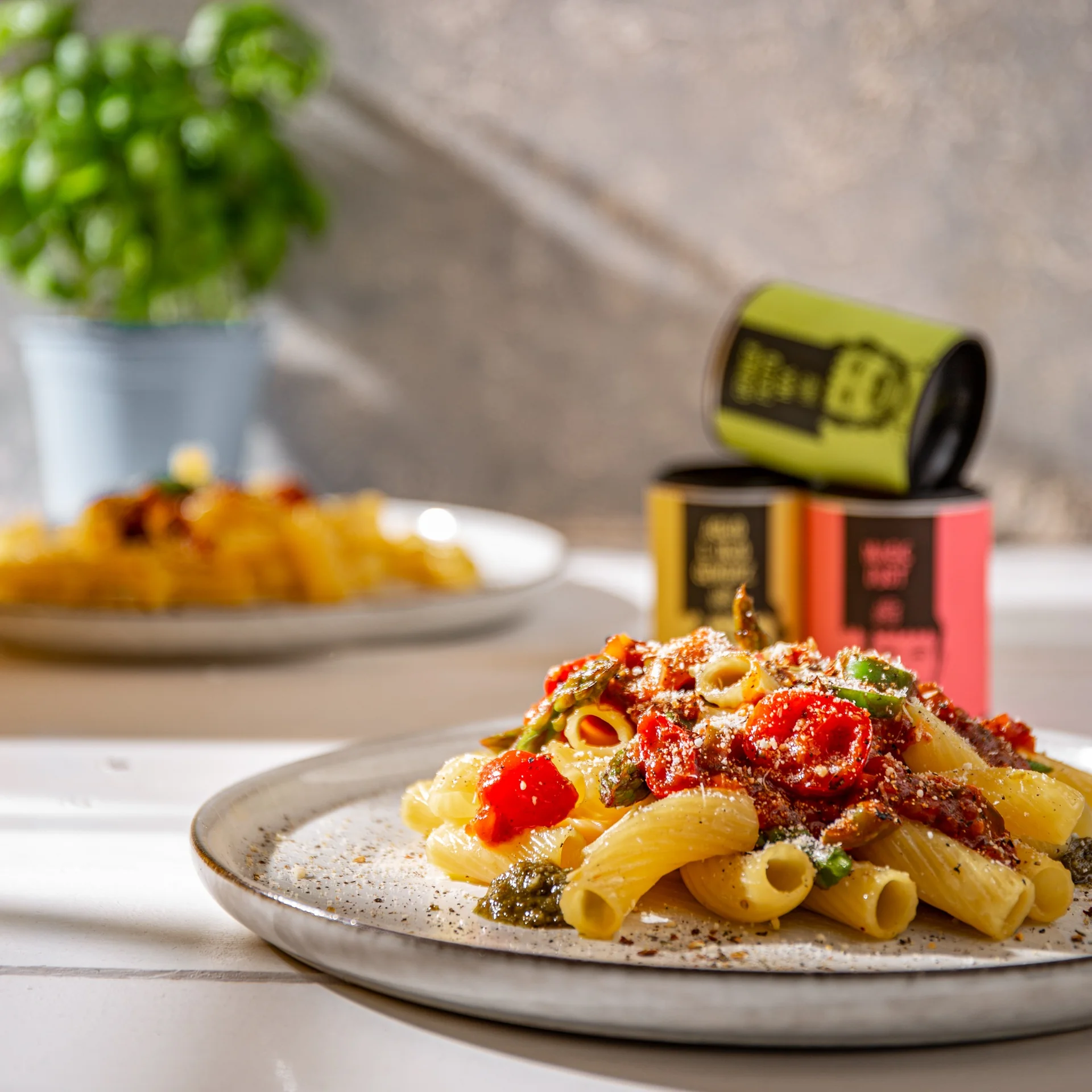 Pasta and tomatoes in the foreground, with Just Spices jars behind the plate